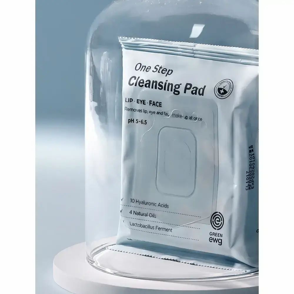 MIZON One Step Reinigungspads unter einer Glasglocke, auf einem weißen Podest.