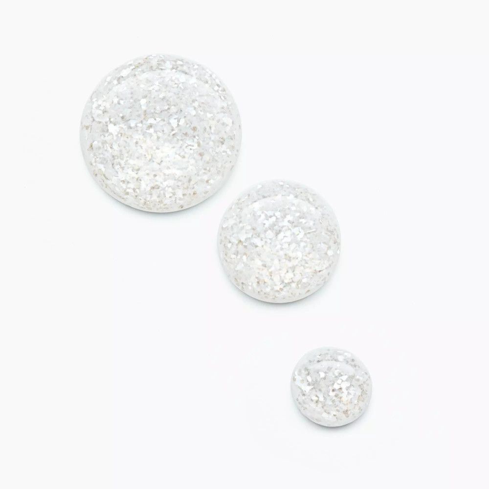 Drei runde, glitzernde Objekte auf weißem Hintergrund. Unterschiedliche Größen, mit glitzernder Oberfläche.