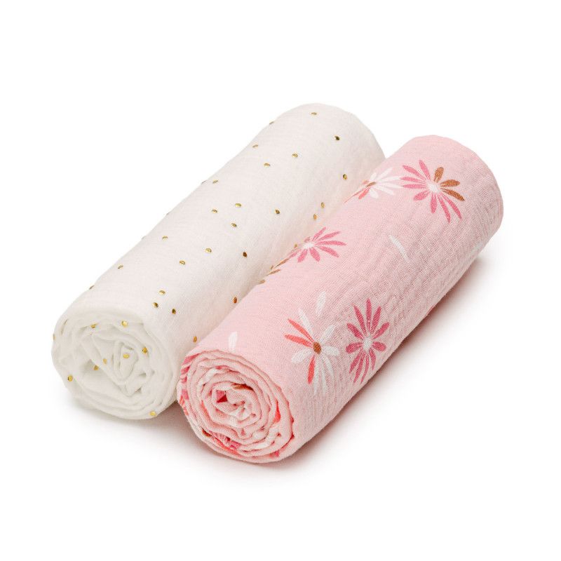 Zwei gerollte Musselin-Windeln. Eine ist weiß mit goldenen Punkten, die andere rosa mit Blumenmuster.