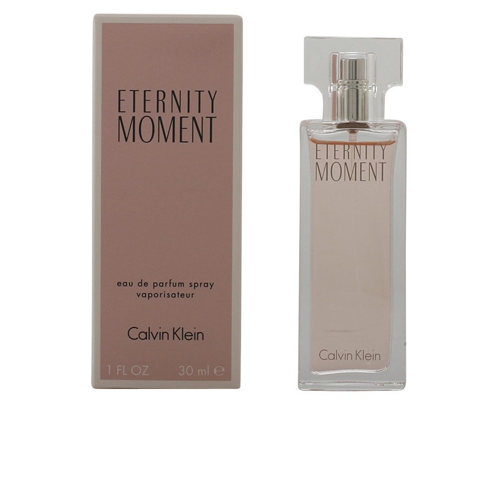 Parfümflasche und Karton. Aufschrift: Eternity Moment. Flasche mit Sprühkopf. Rosa Flüssigkeit. Calvin Klein.