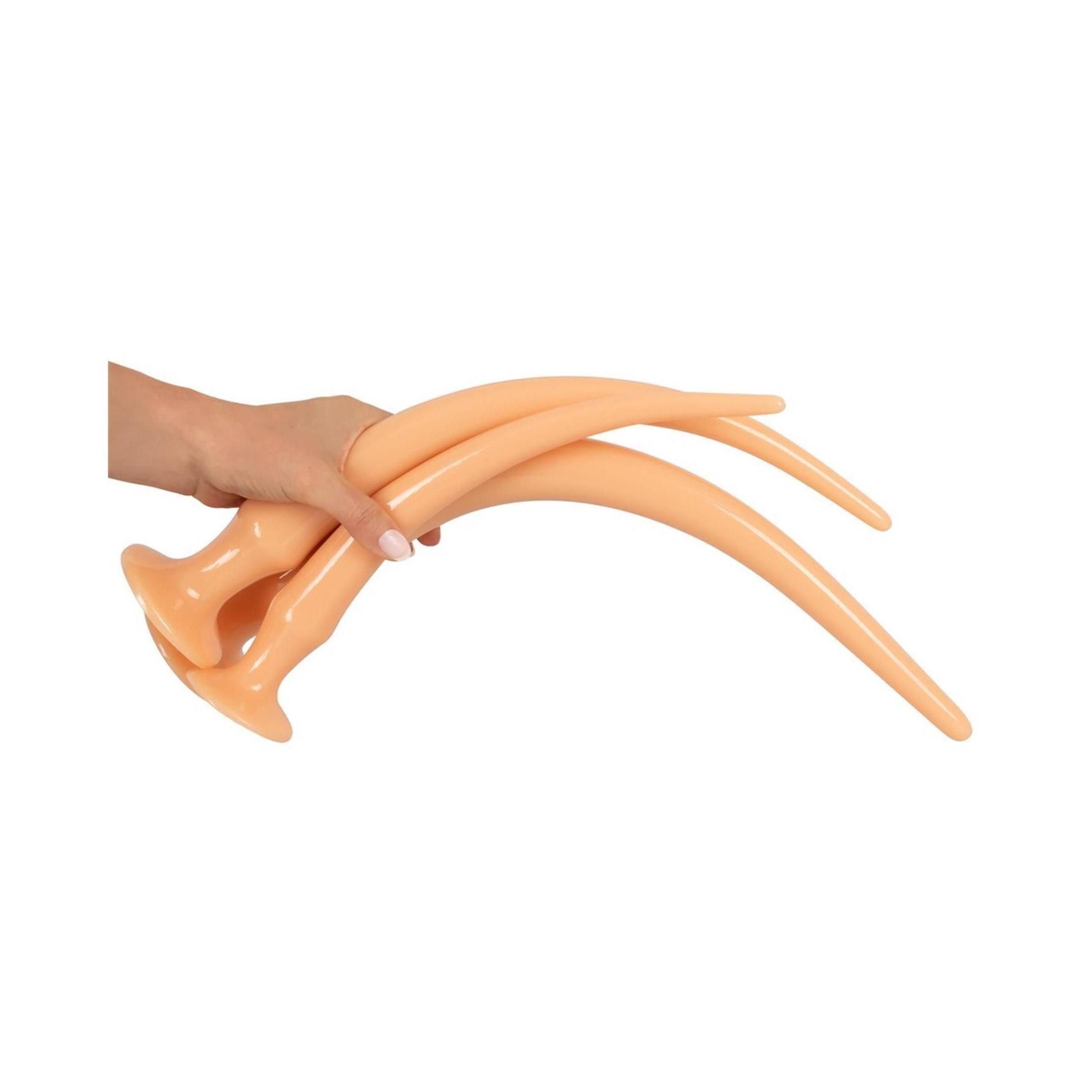 Hand hält zwei beige, gebogene Anal-Plug-Spielzeuge. Mit Basis.