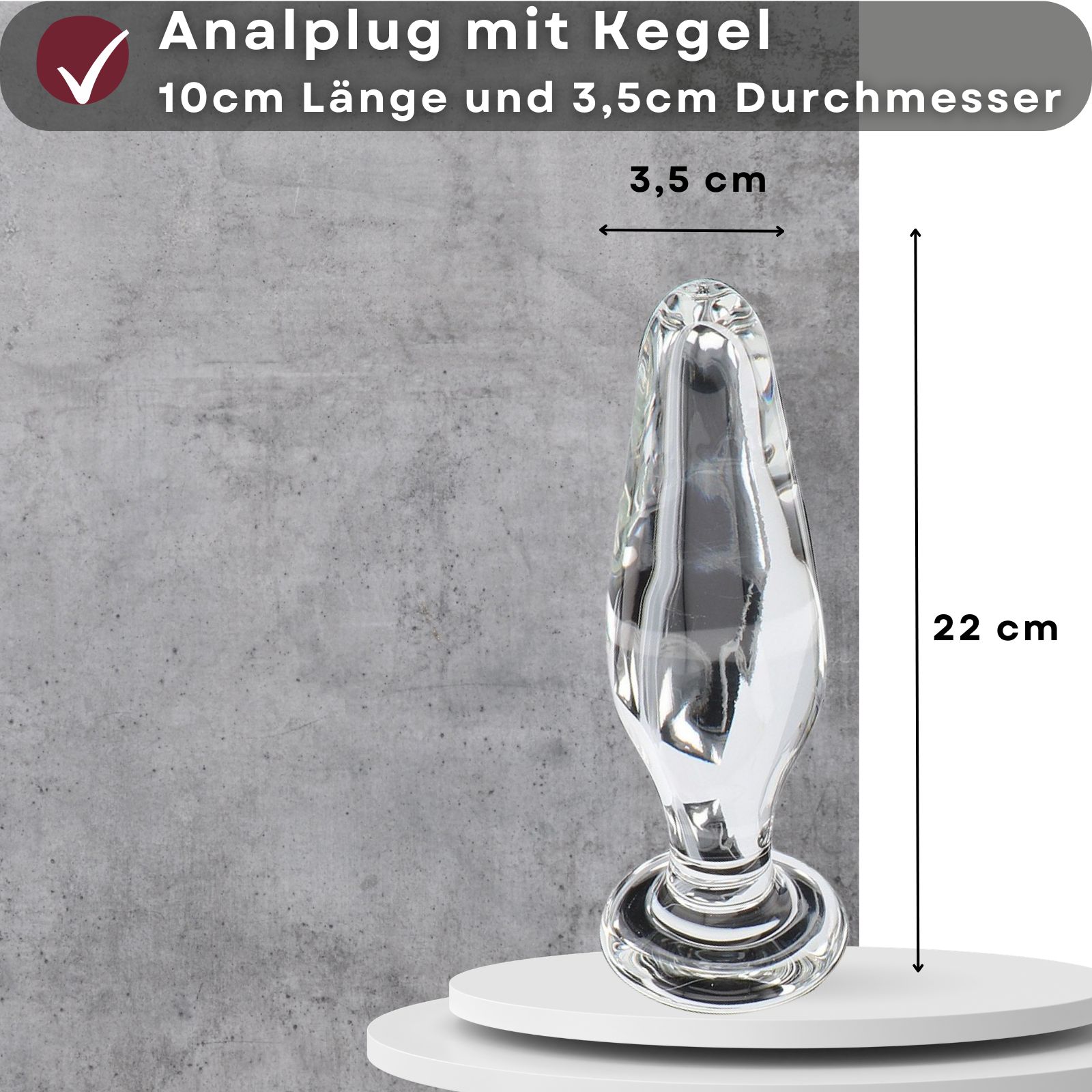 Analplug mit Kegel. 10cm lang, 3,5cm Durchmesser. Transparentes Material. Auf weißem Podest.