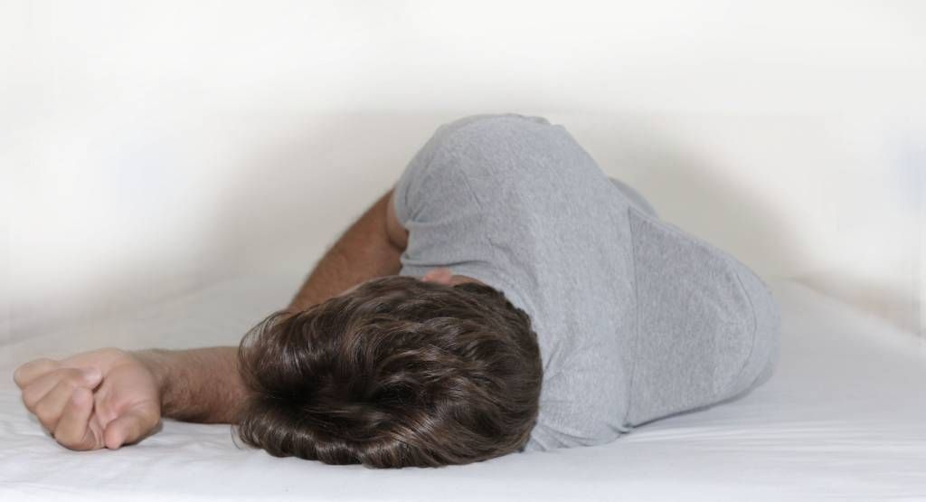 Graues T-Shirt mit angenähtem, rechteckigem Rückenteil. Seitenansicht, Produkt freigestellt.