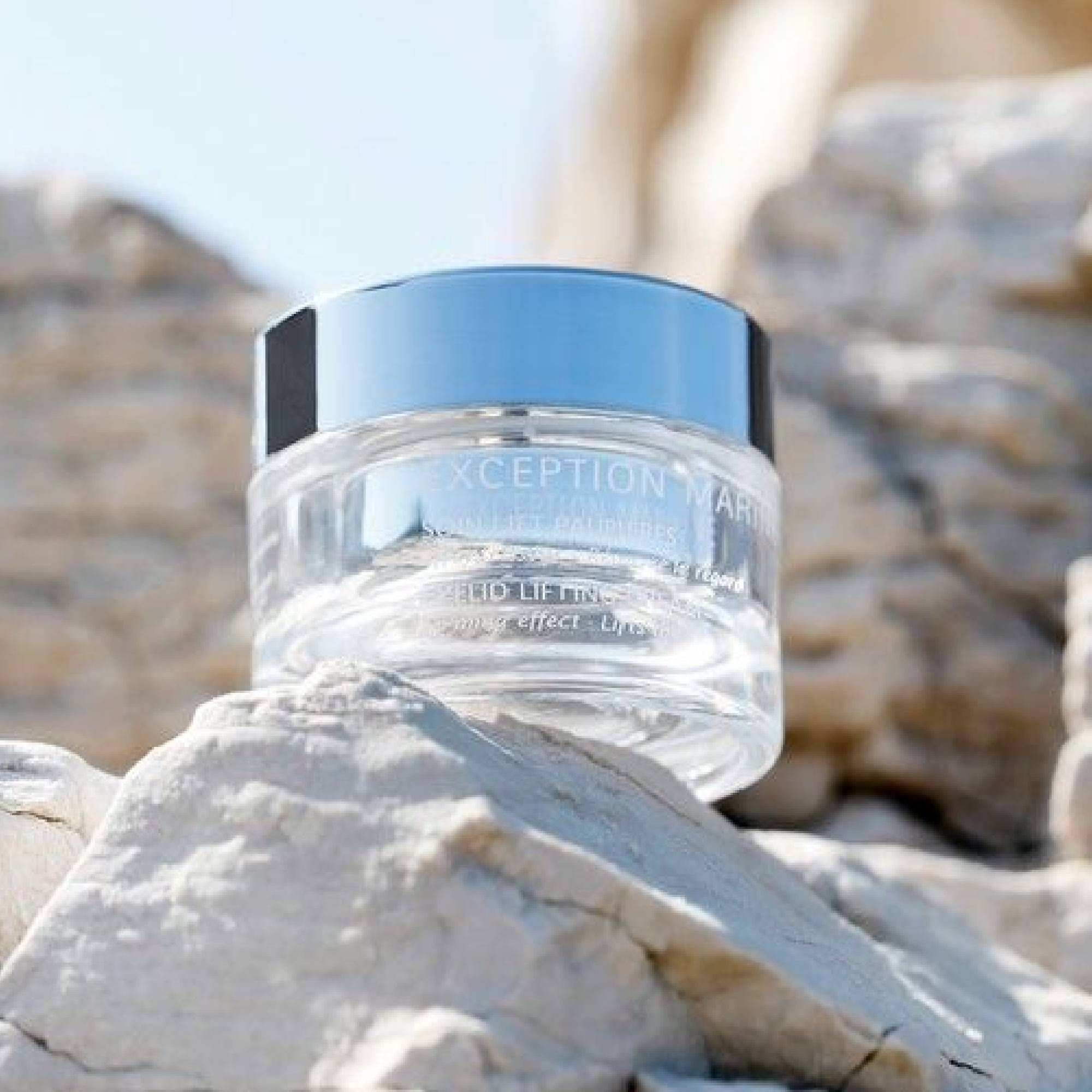 Klarer Tiegel mit silbernem Deckel. Aufschrift: XCEPTION MARINE. Auf Felsen platziert.