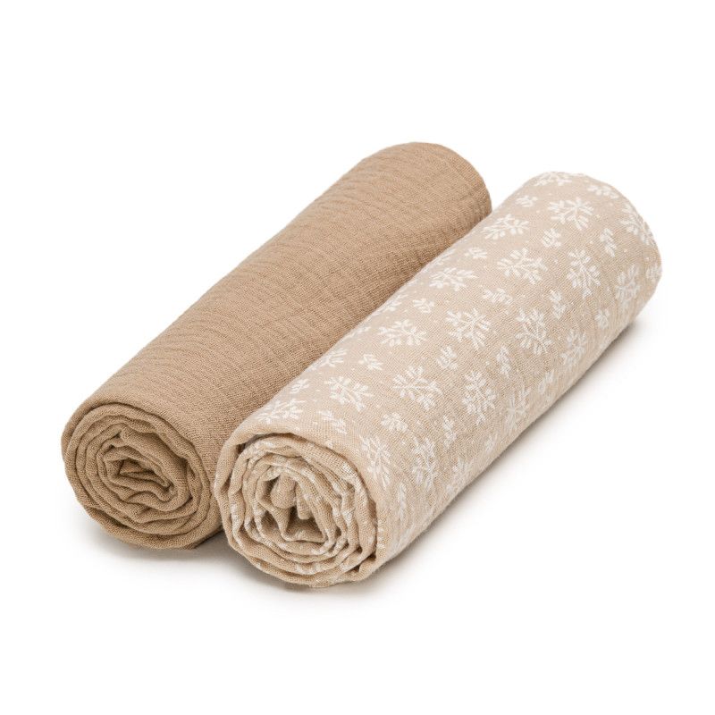 Zwei gerollte Musselin-Windeln. Eine beige, eine mit weißem Muster. Beide aus Stoff.