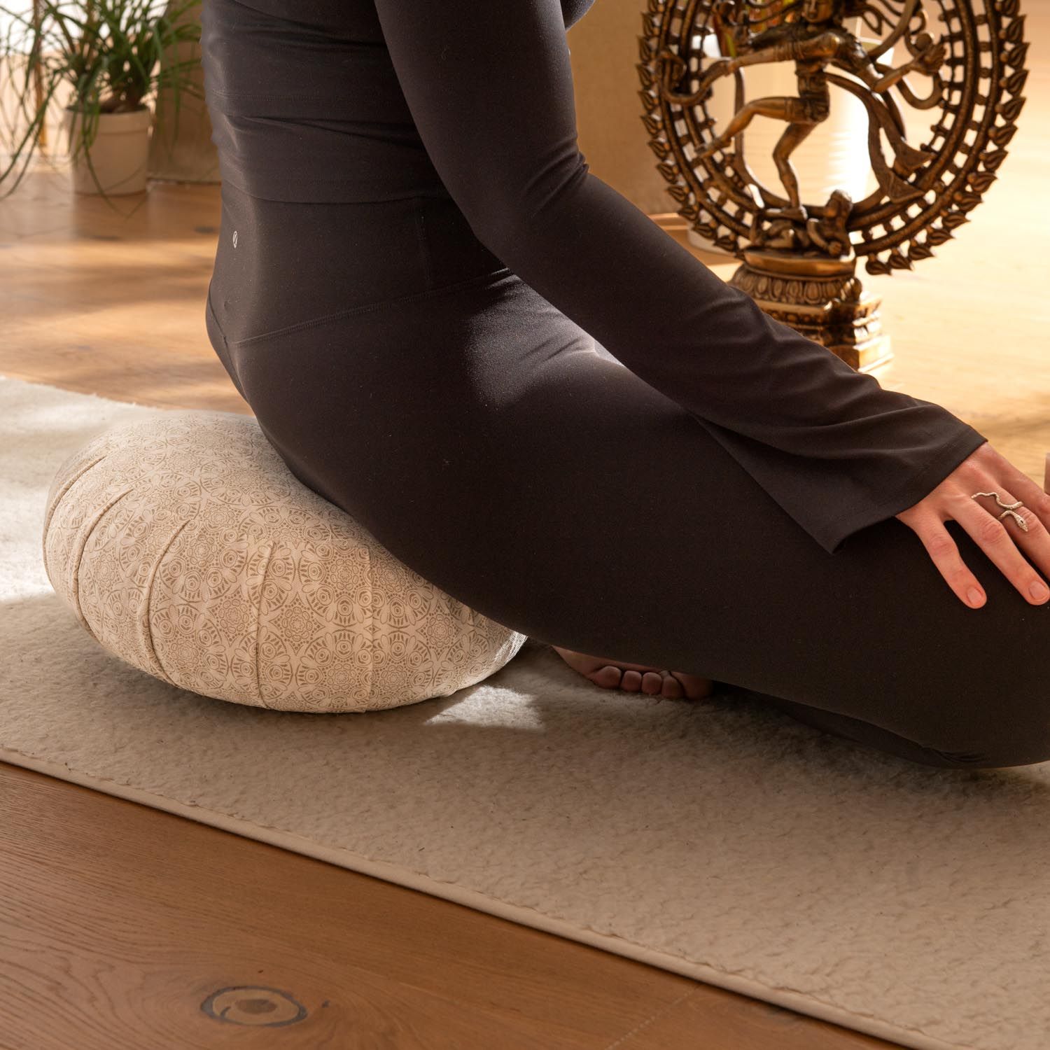 Bodhi Zafu Meditationskissen mit Muster, von einer sitzenden Person verwendet.
