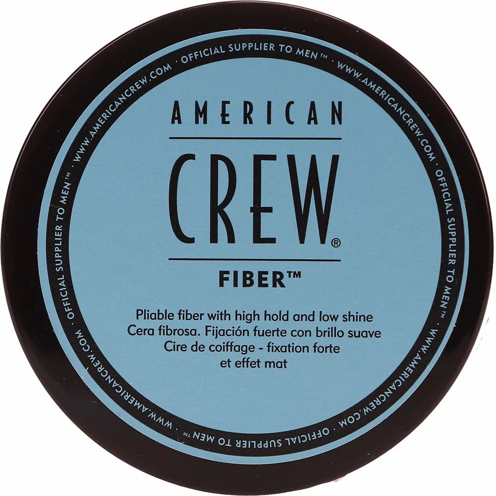 Dunkelblaue Dose mit "AMERICAN CREW FIBER"-Aufschrift. Text in Englisch, Spanisch und Französisch.