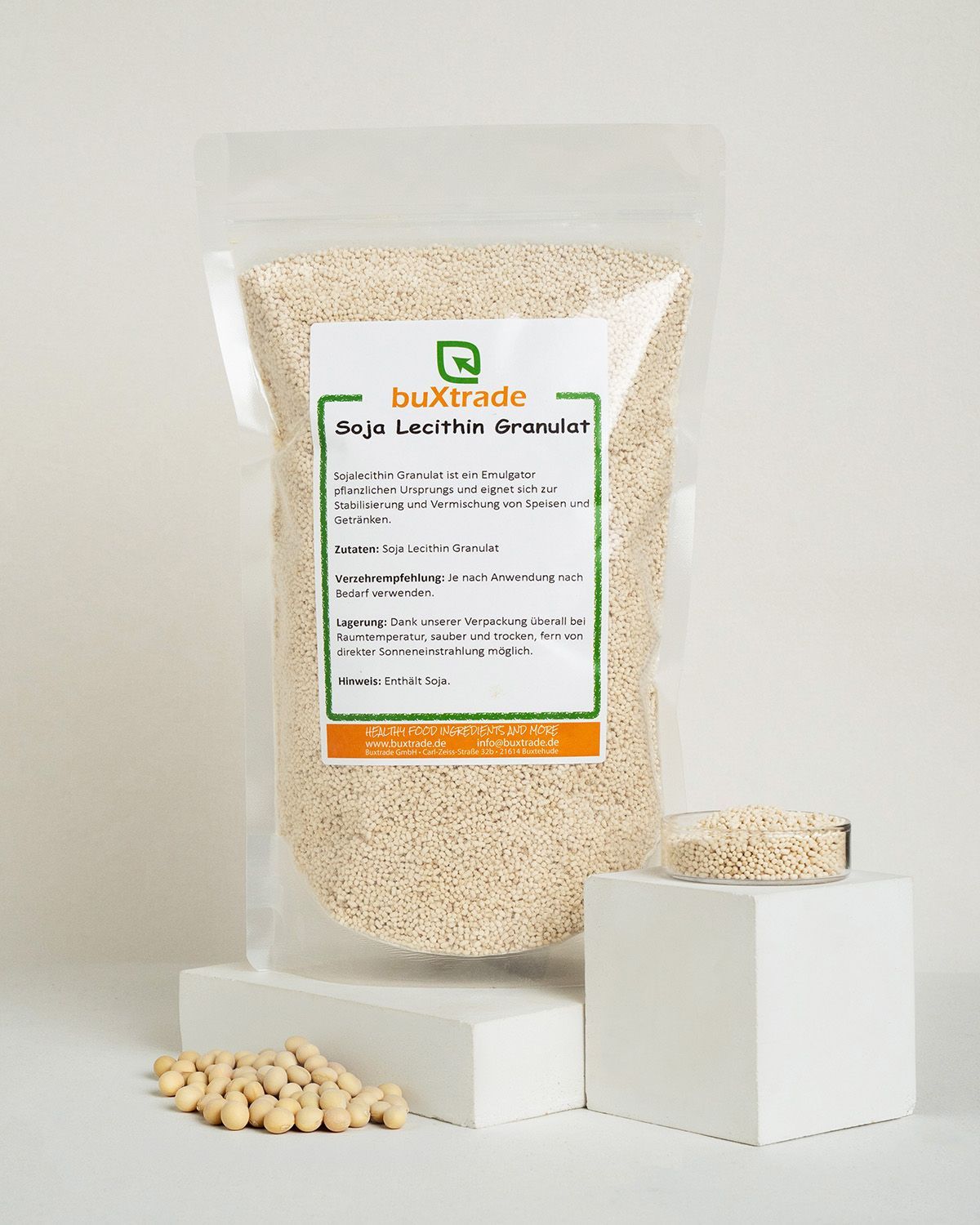Verpackung mit buxtrade Soja Lecithin Granulat, Granulat in Glasschale und auf Würfeln.