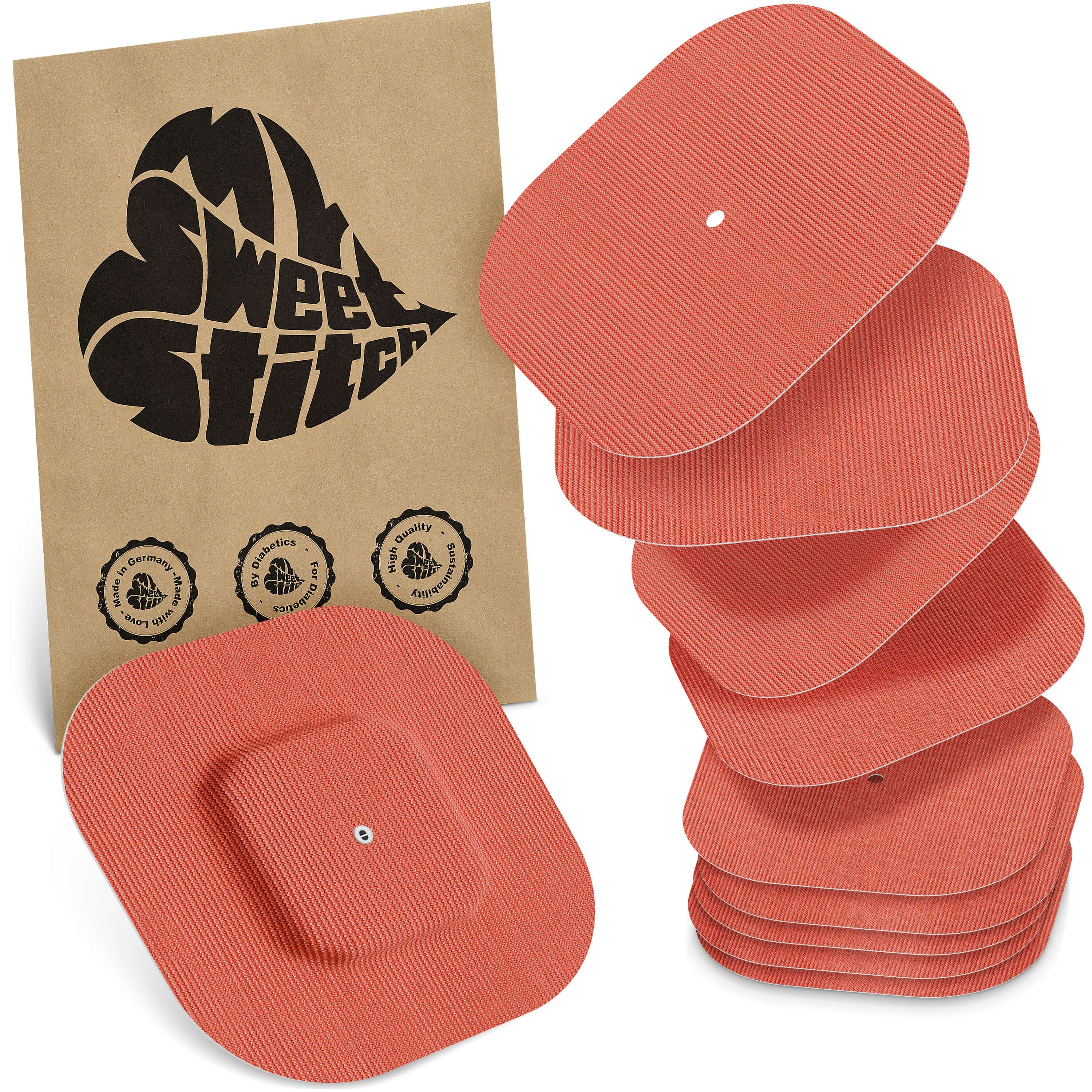 Beige Verpackung mit Logo. Daneben mehrere orangefarbene, rechteckige Pflaster mit abgerundeten Ecken. Einige haben ein Loch.