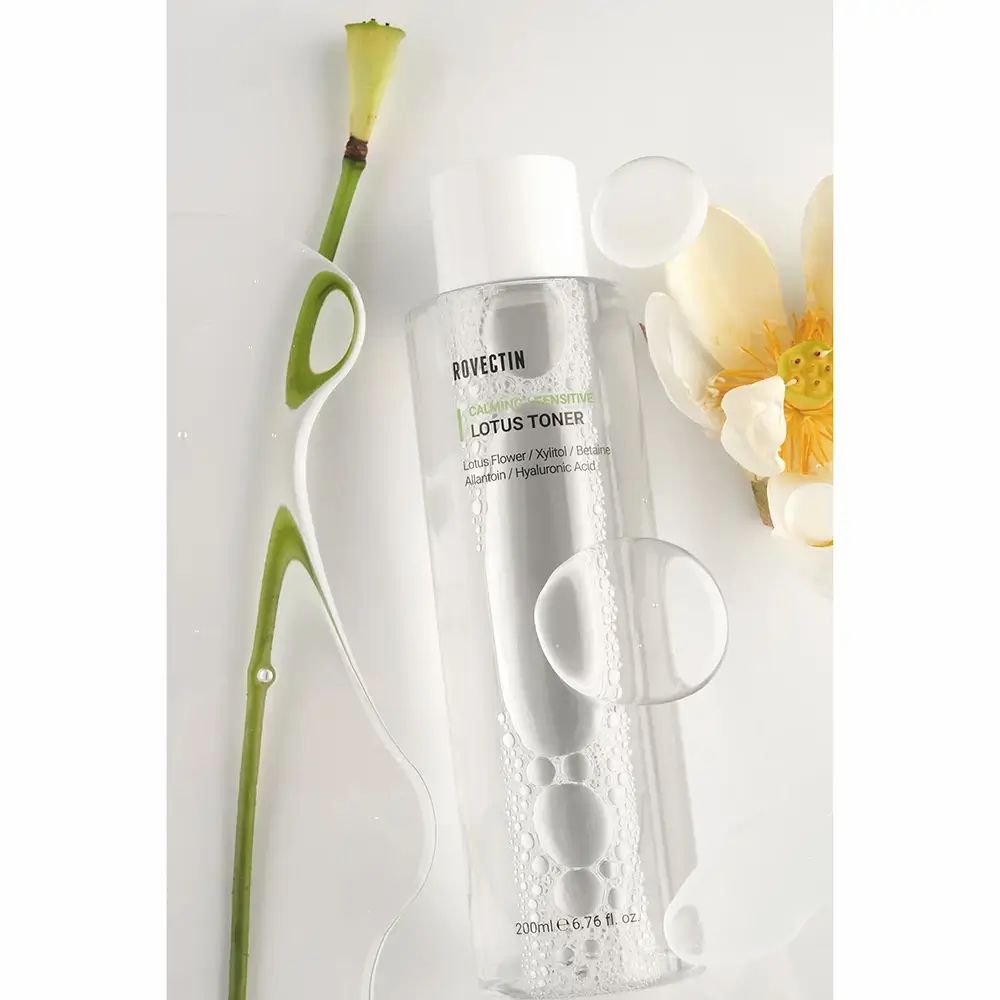 Transparente Flasche mit weißem Deckel. ROVECTIN Calming Lotus Toner. Lotusblüte und Stiel.