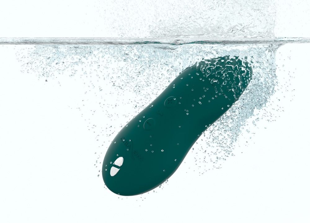 Grünes Wellness-Produkt im Wasser. Längliche Form, leicht abgerundet. Wasser spritzt um das Produkt herum.