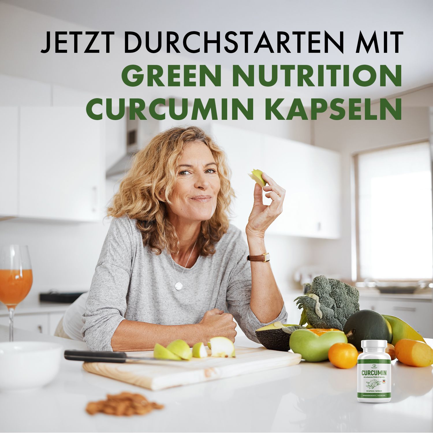 Frau in Küche hält Stück Obst, neben CURCUMIN Kapseln. Text: Jetzt durchstarten mit Green Nutrition CURCUMIN Kapseln.