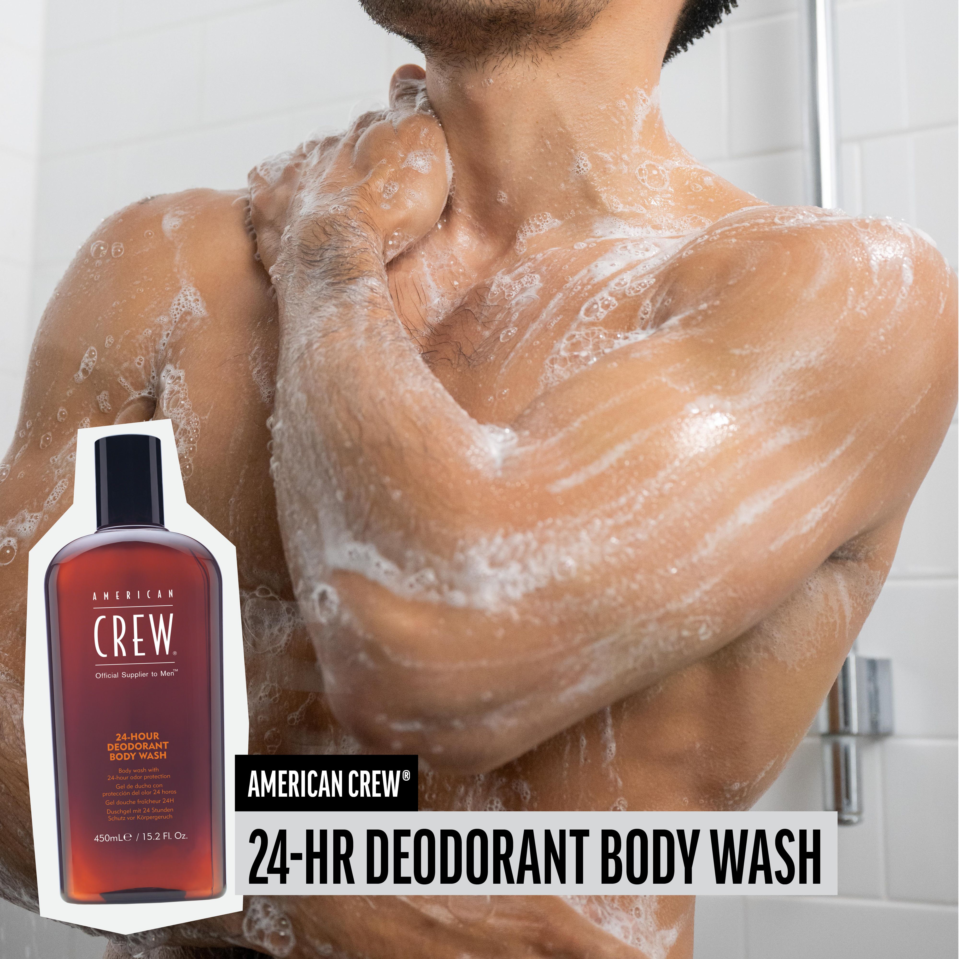 Mann duscht sich. Neben ihm: Flasche AMERICAN CREW 24-HR DEODORANT BODY WASH. Schaum auf der Haut.