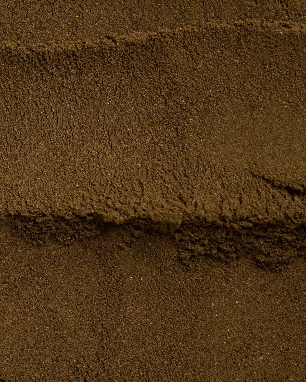 Nahaufnahme von braunem Pulver. Feine Textur, gleichmäßig verteilt.