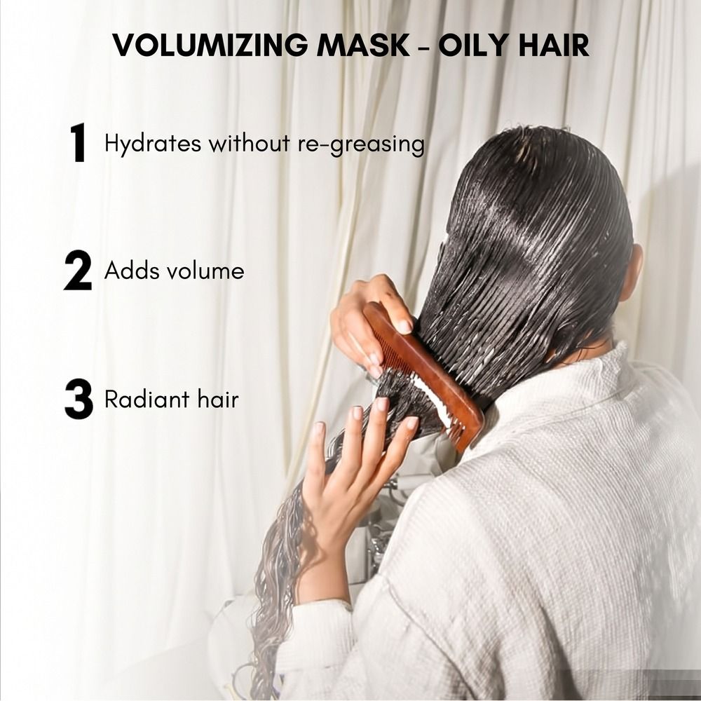 Eine Person kämmt nasses Haar, auf das eine weiße Maske aufgetragen wurde. Text: 'VOLUMIZING MASK - OILY HAIR'.