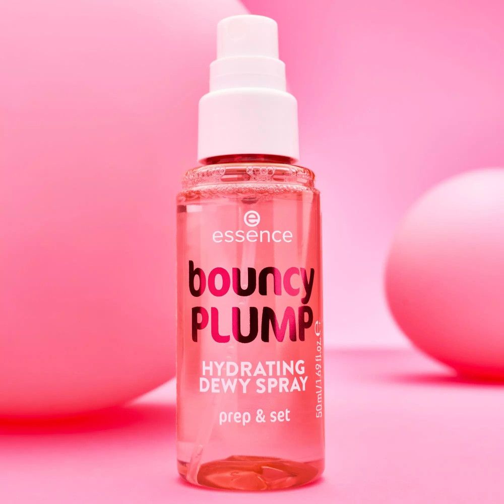 Rosa Flasche mit weißem Sprühkopf. Aufschrift: bouncy PLUMP, Hydrating Dewy Spray, prep & set. Marke: essence. Hintergrund: rosa.