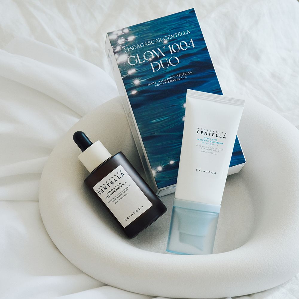 Duo-Set mit Serum, Ampulle und Verpackung. Auf weißem Stoff. Ampulle und Serum in Flaschen. Verpackung mit blauem Design.