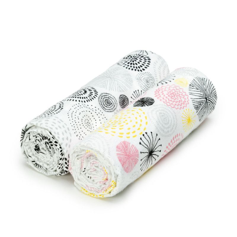 Zwei gerollte Stoffbadetücher mit floralem Muster. Farben: Schwarz, Grau, Gelb und Rosa auf weißem Grund. Baumwolle.