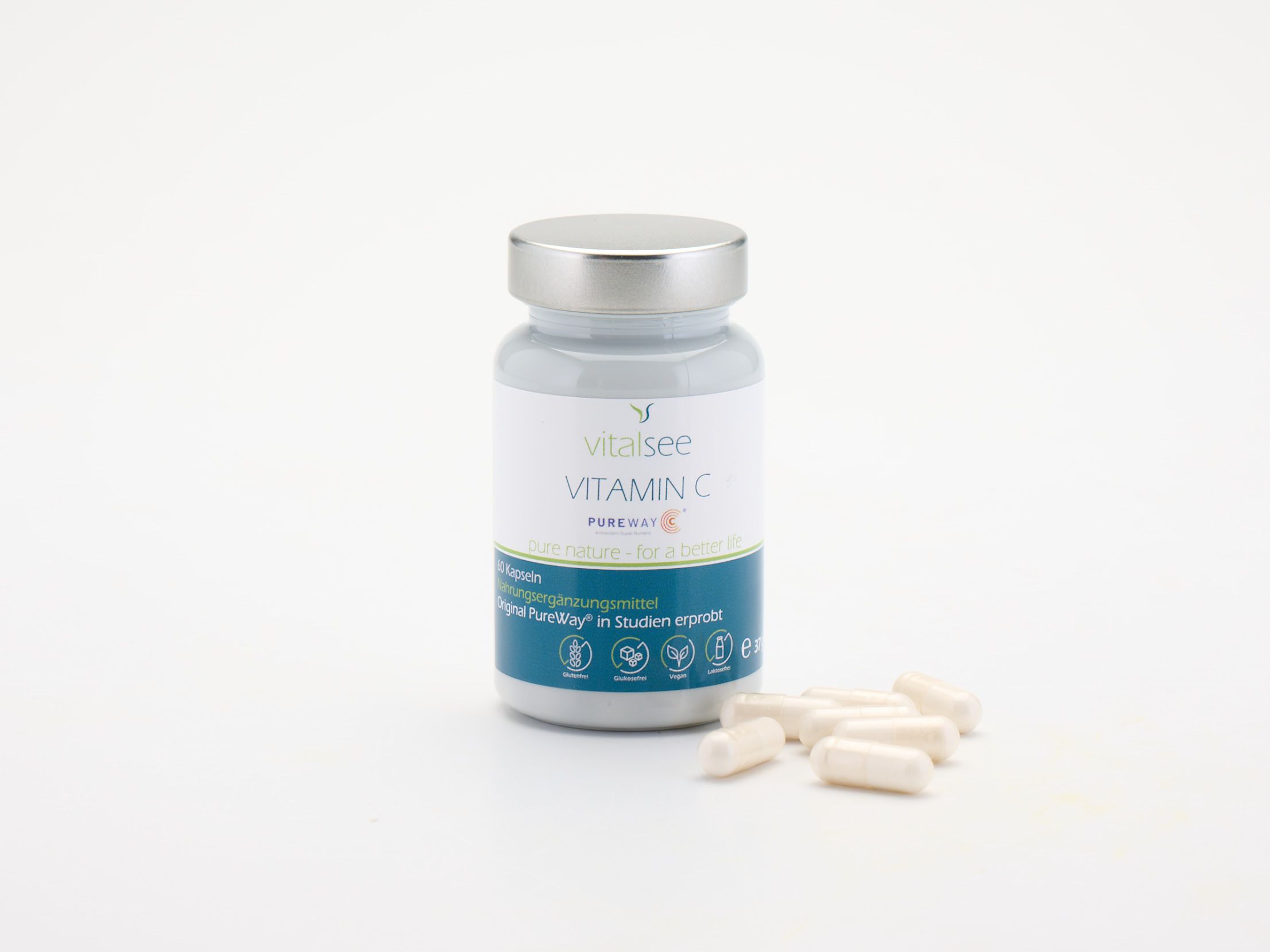 Flasche mit Vitamin C Kapseln und verstreuten Kapseln daneben. Weißes Etikett, silberner Deckel.