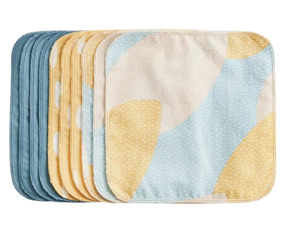 Mehrere quadratische Waschlappen. Einige blau, gelb und weiß gepunktet. Abgerundete Ecken. Stoff aus Bio-Baumwolle.