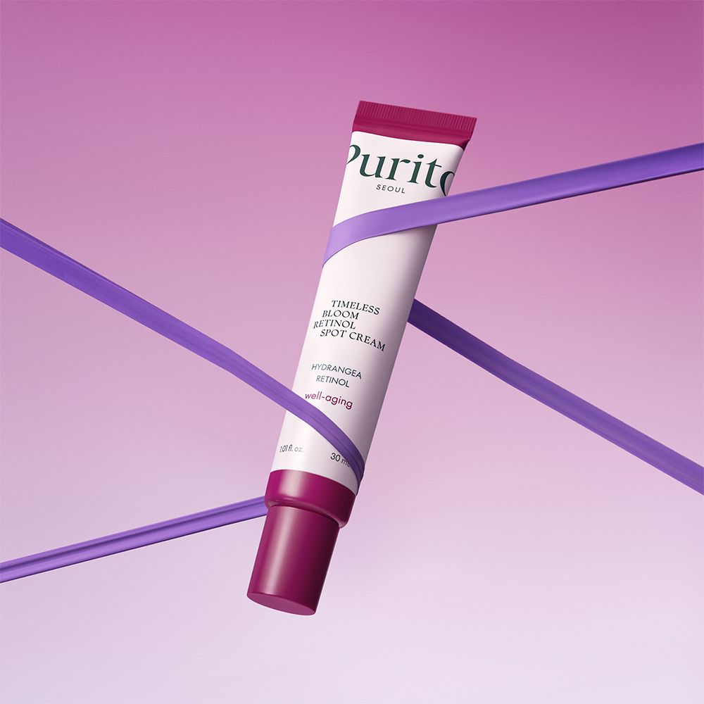 PURITO Timeless Bloom Retinol Spot Cream Tube, umhüllt von violetten Bändern.