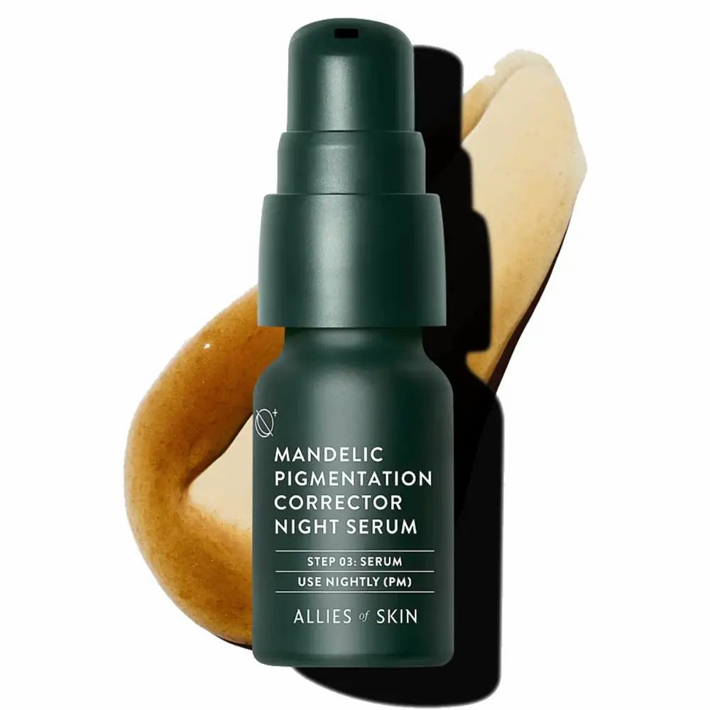 Grüne Flasche mit Pumpe. Aufschrift: Mandelic Pigmentation Corrector Night Serum. Gelbliche Flüssigkeit daneben.