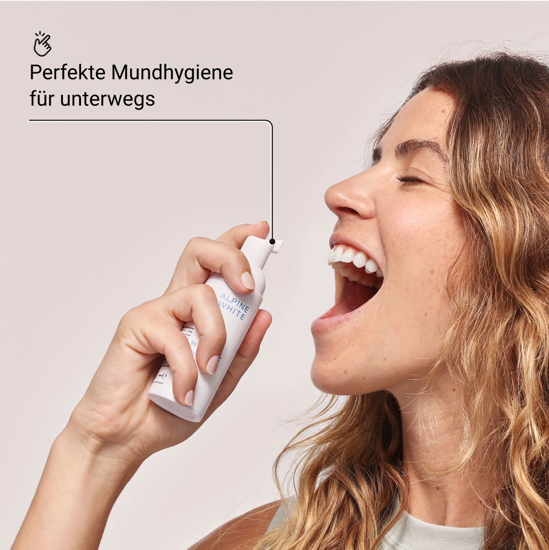 Frau sprüht „ALPINE WHITE Whitening Foam“ in den Mund. Text: Perfekte Mundhygiene für unterwegs.