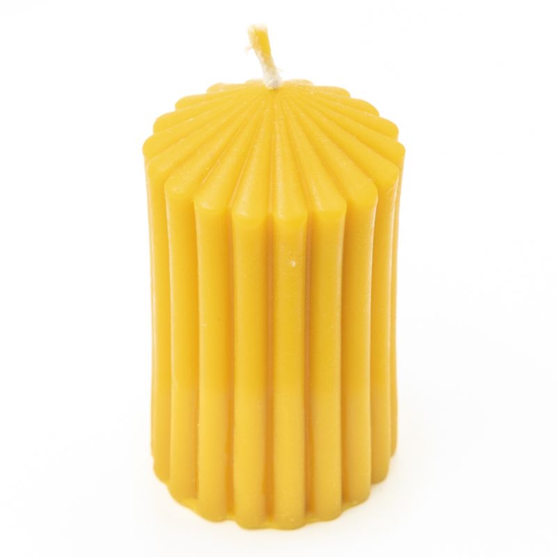 Gelbe Wachskerze mit geriffelter Oberfläche. Zylindrische Form mit spitz zulaufendem oberen Ende. Docht sichtbar.