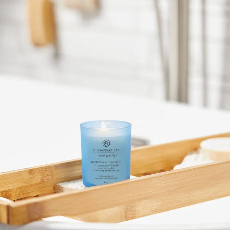 Blaue Kerze Chesapeake Bay, Confiance + liberté, auf einem Holztablett in einem Badezimmer. Mit Mind & Body Aufschrift.