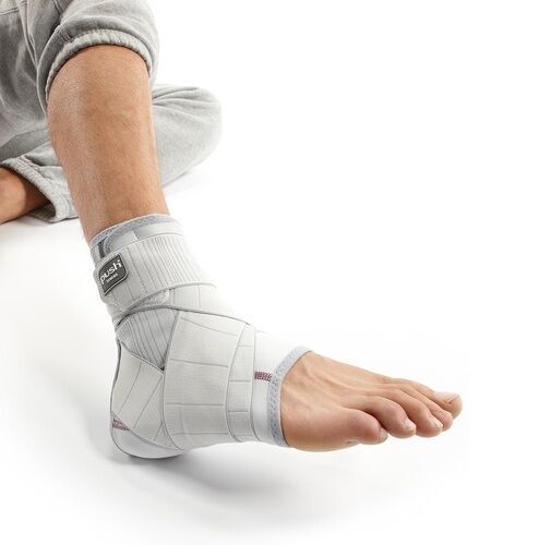 Knöchelbandage am Fuß. Hellgrau mit Klettverschlüssen und dem Logo "push".