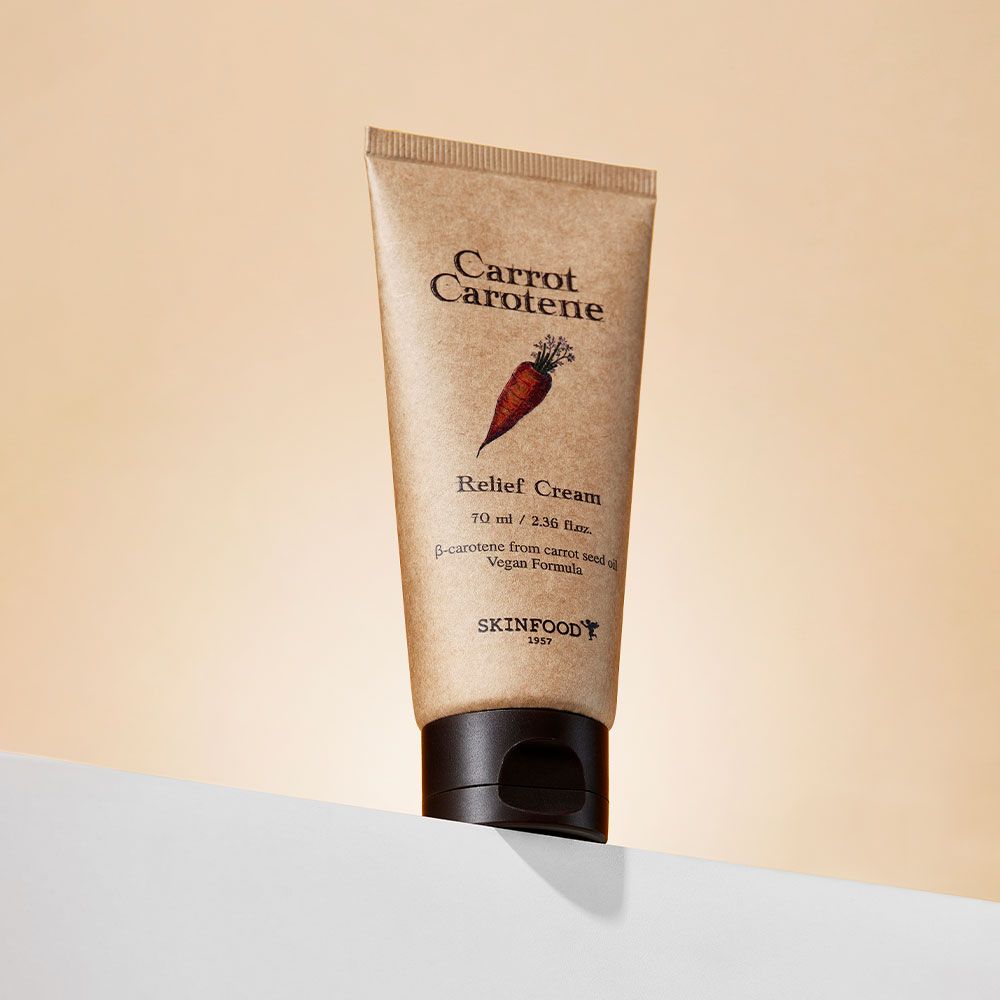 Beige Tube mit braunem Deckel auf weißer Oberfläche. Aufschrift: Carrot Carotene, Relief Cream, SKINFOOD.