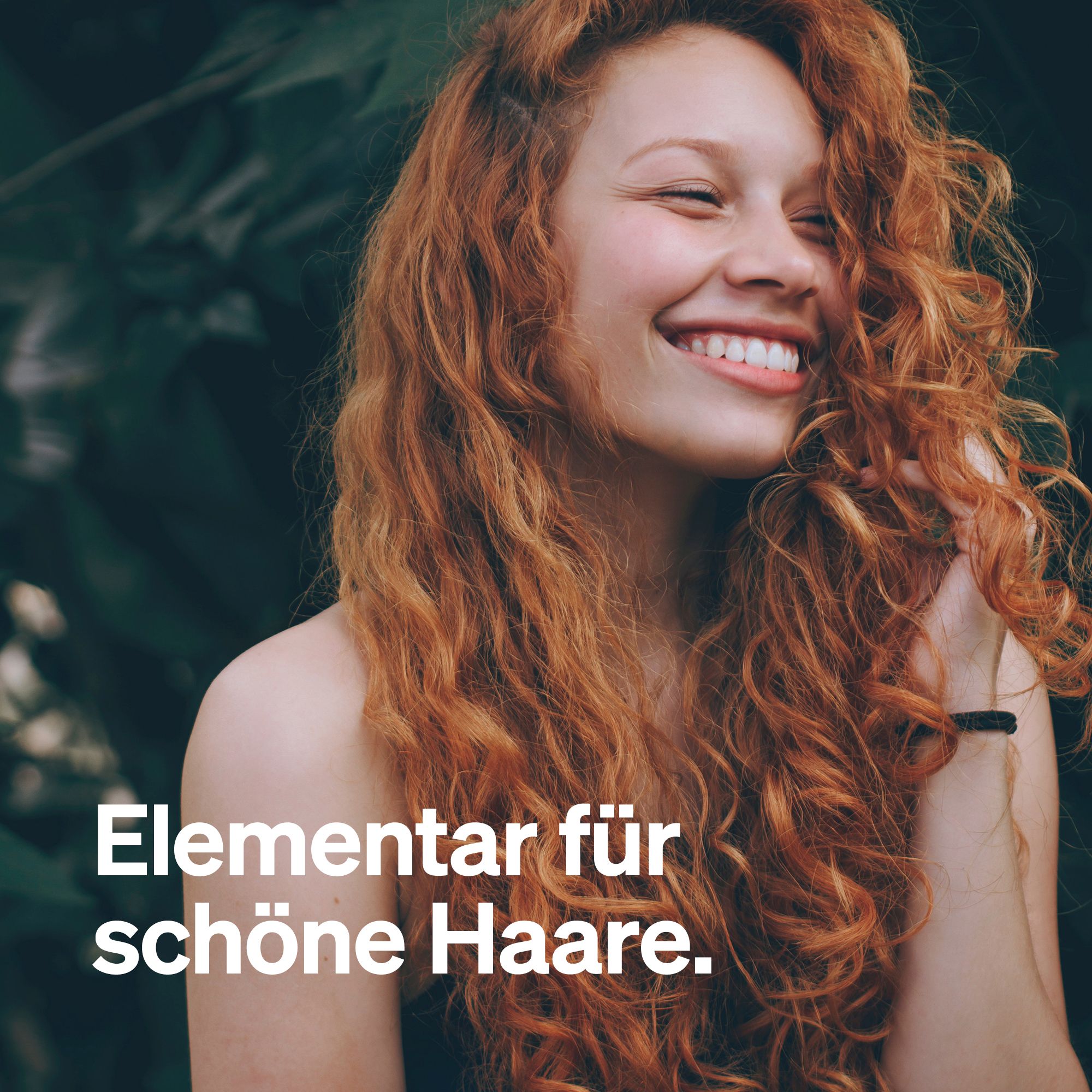 Eine lächelnde Frau mit roten Locken. Text: Elementar für schöne Haare.