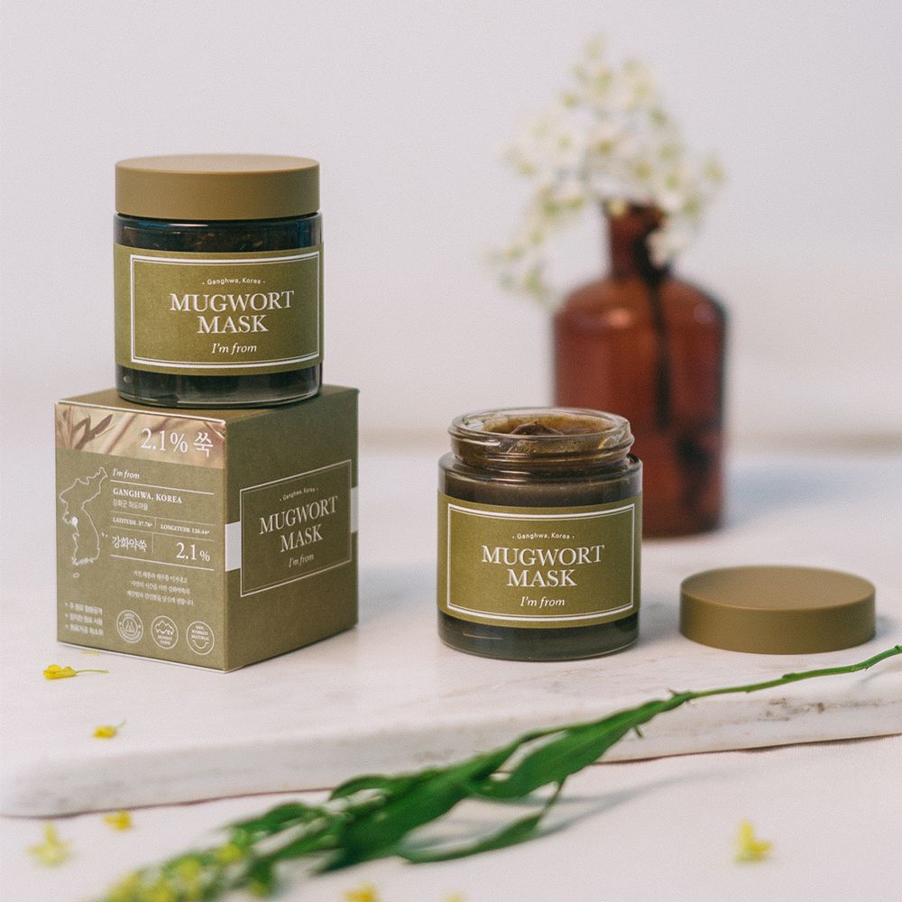 Zwei Gläser und eine Schachtel der Mugwort Maske. Aufschrift: I'M FROM Mugwort Mask. Braune Gläser mit grünem Deckel und Etikett.