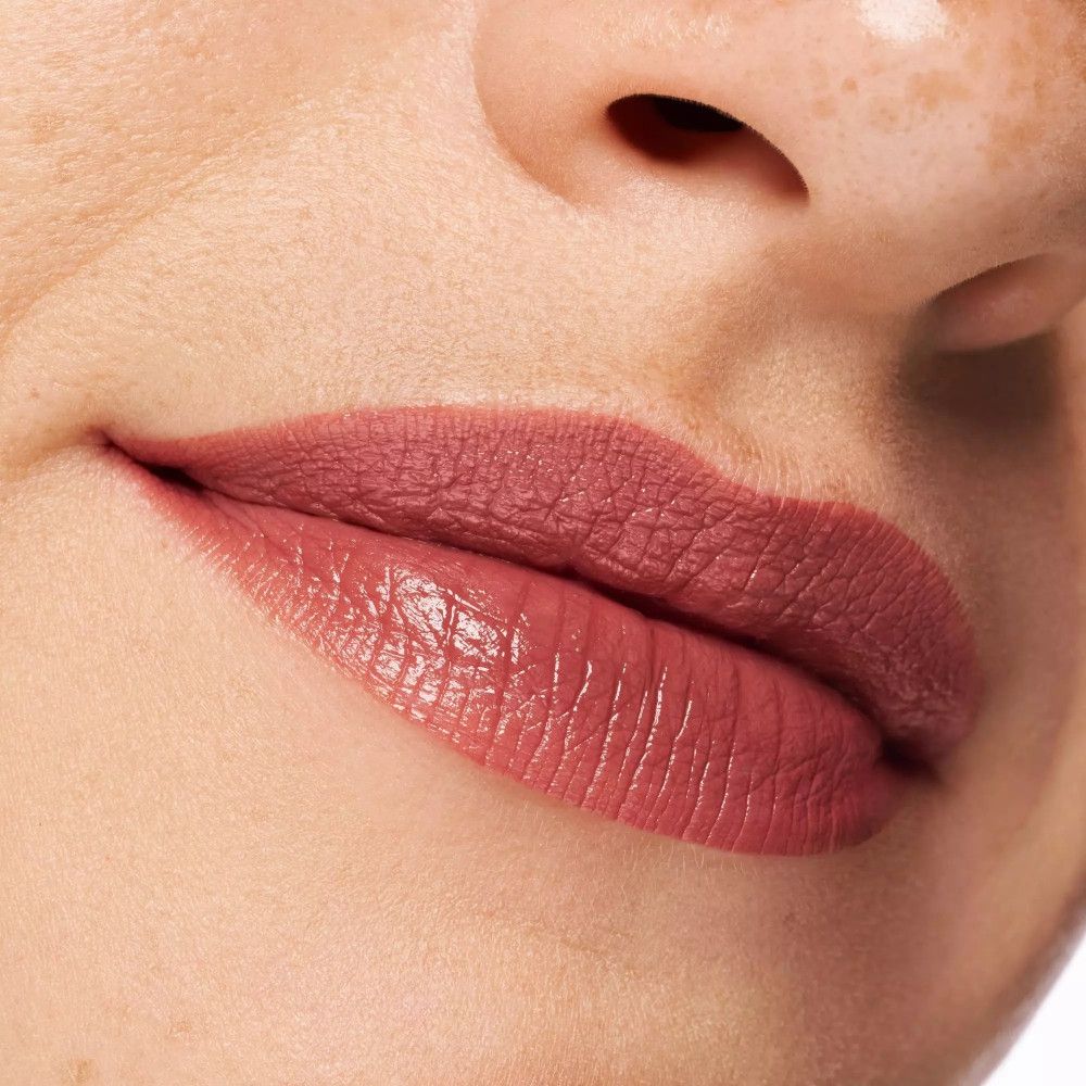 Nahaufnahme von Lippen mit Lippenstift. Lippen in Rosé-Ton geschminkt. Haut mit Glanz.
