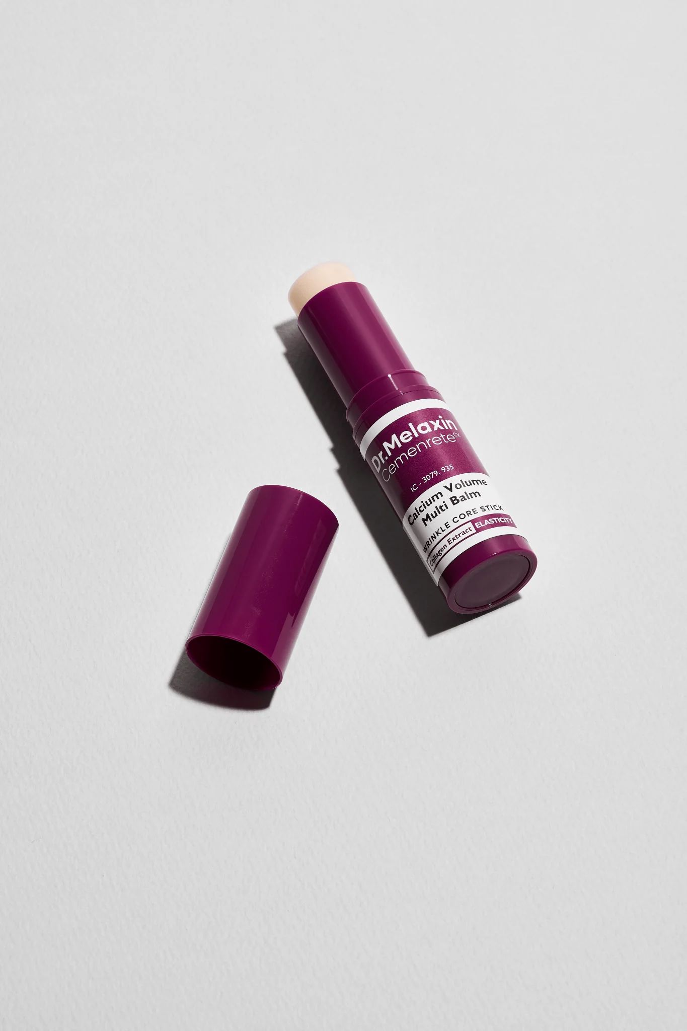Dr.Melaxin Cemenrete Calcium Volume Multi Balm. Produkt mit geöffneter Kappe. Lila Verpackung, weißer Text.