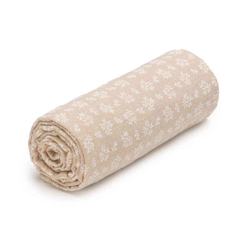 Gerolltes Musselintuch. Beige mit weißem floralen Muster. Stoffstruktur sichtbar.