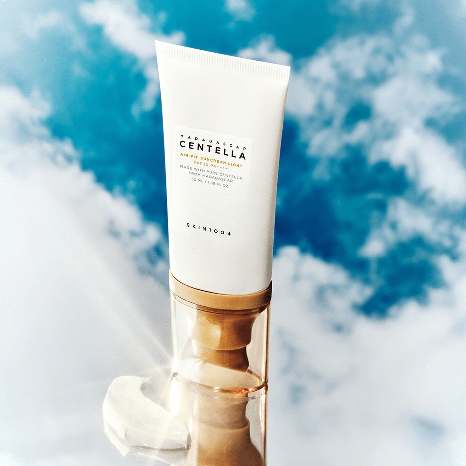 SKIN1004 Air-Fit Suncream Light SPF30 Tube auf einem Spiegel vor einem Himmelshintergrund.