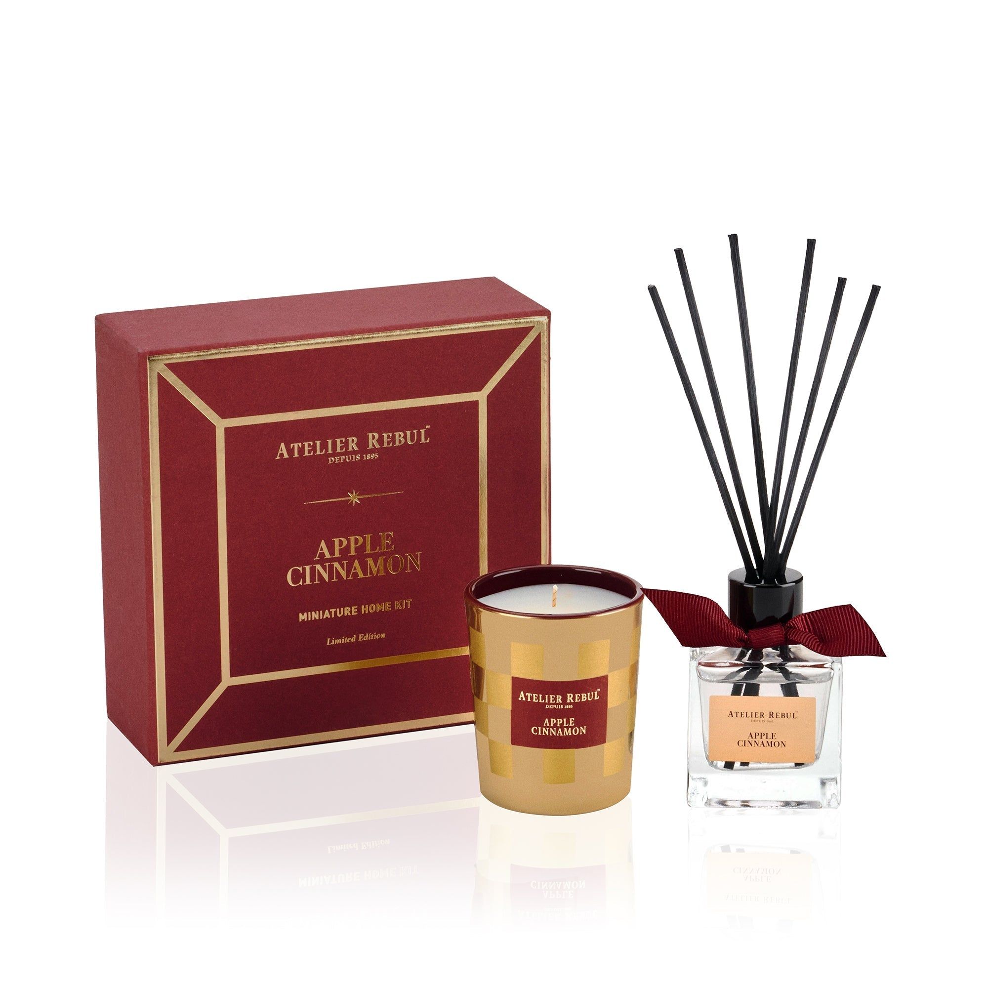 Geschenkset mit Kerze, Duftdiffusor und Box. Rote Box, goldene Kerze, Glasflasche. Atelier Rebul-Logo und Produktname.
