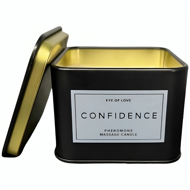 Schwarze, quadratische Dose mit geöffnetem Deckel. Aufschrift: CONFIDENCE, Pheromon Massage Candle. Goldfarbene Innenseite.