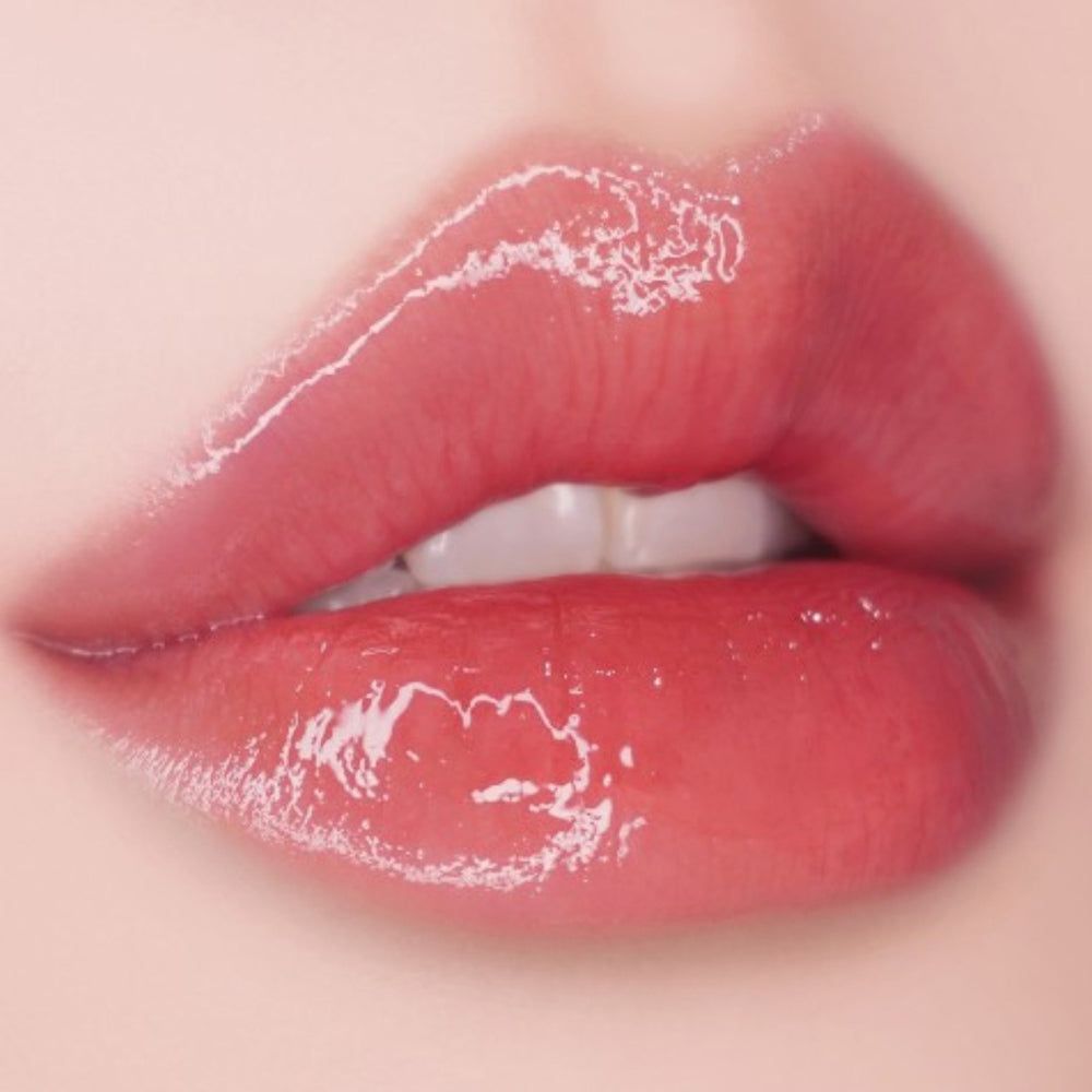 Nahaufnahme von vollen, glänzenden Lippen. Die Lippen sind rosa und haben einen glänzenden Effekt.