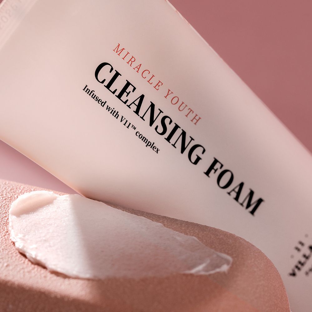 Nahaufnahme einer Tube mit Aufschrift MIRACLE YOUTH CLEANSING FOAM. Auf einer Hautpartie ist Schaum aufgetragen.