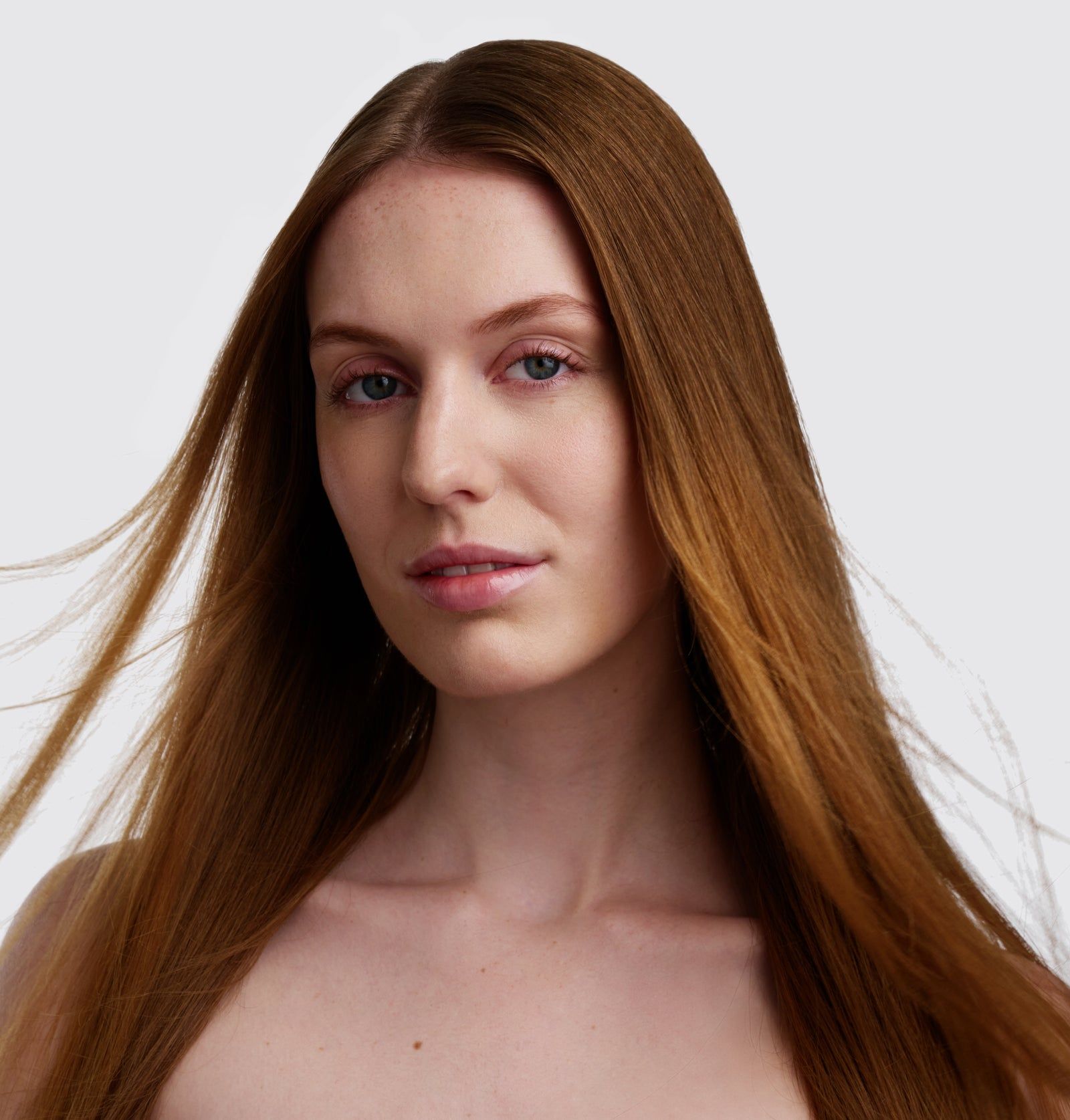 Porträt einer Frau mit langen, braunen Haaren. Sie blickt in die Kamera.