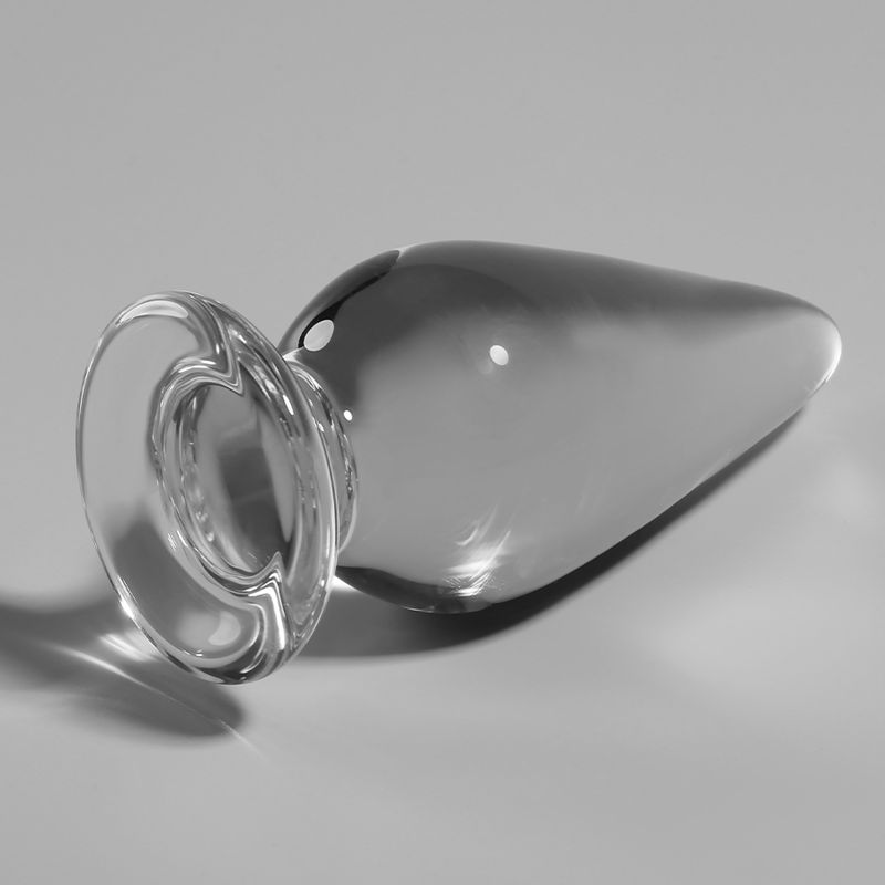 Analplug aus Glas, transparent. Liegend. Runde Basis, tropfenförmiger Schaft.