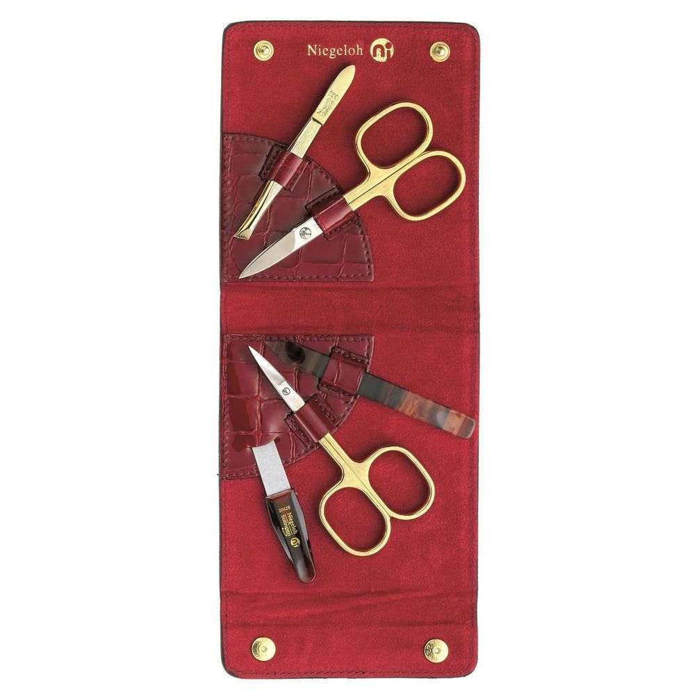 Rotes Lederetui mit goldenen Scheren, Nagelfeile und Pinzette. Marke Niegeloh.