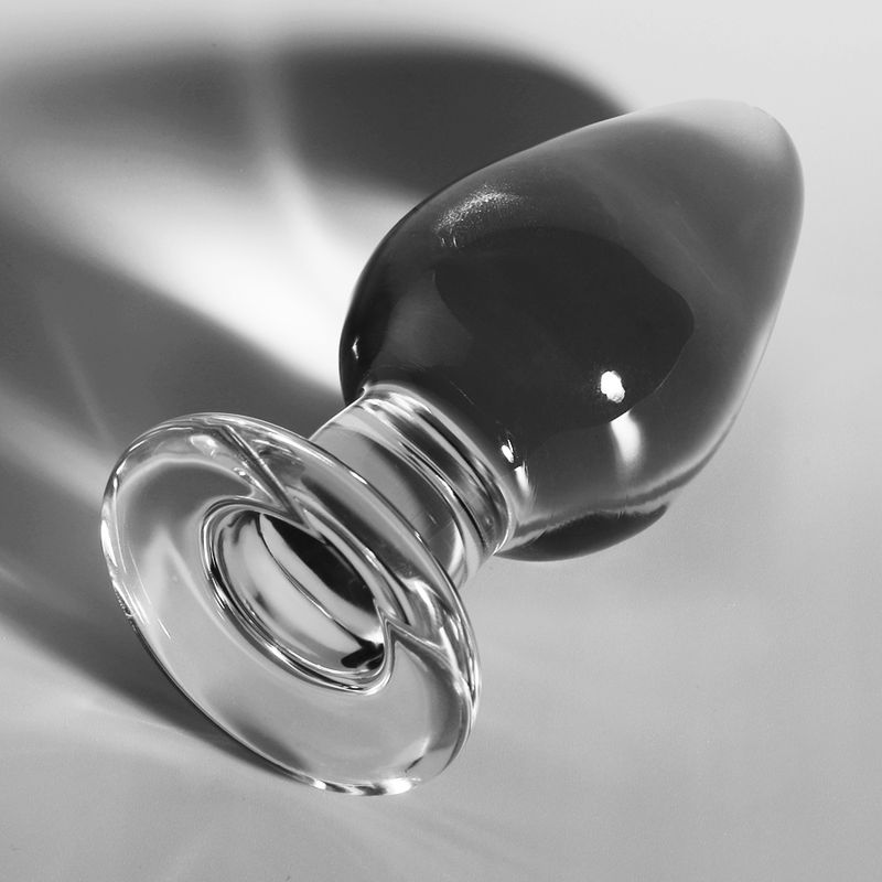 Klarer Glas-Analplug mit breiter, gerippter Basis, spitz zulaufend. Seitenansicht, Schattenwurf.