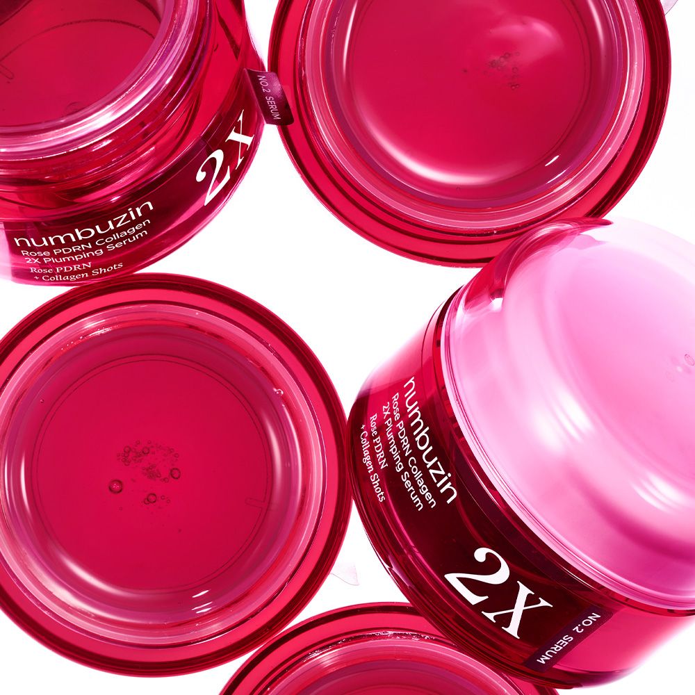 Mehrere offene rote Tiegel mit NUMBUZIN Rose PDRN Collagen 2X Plumping Serum.