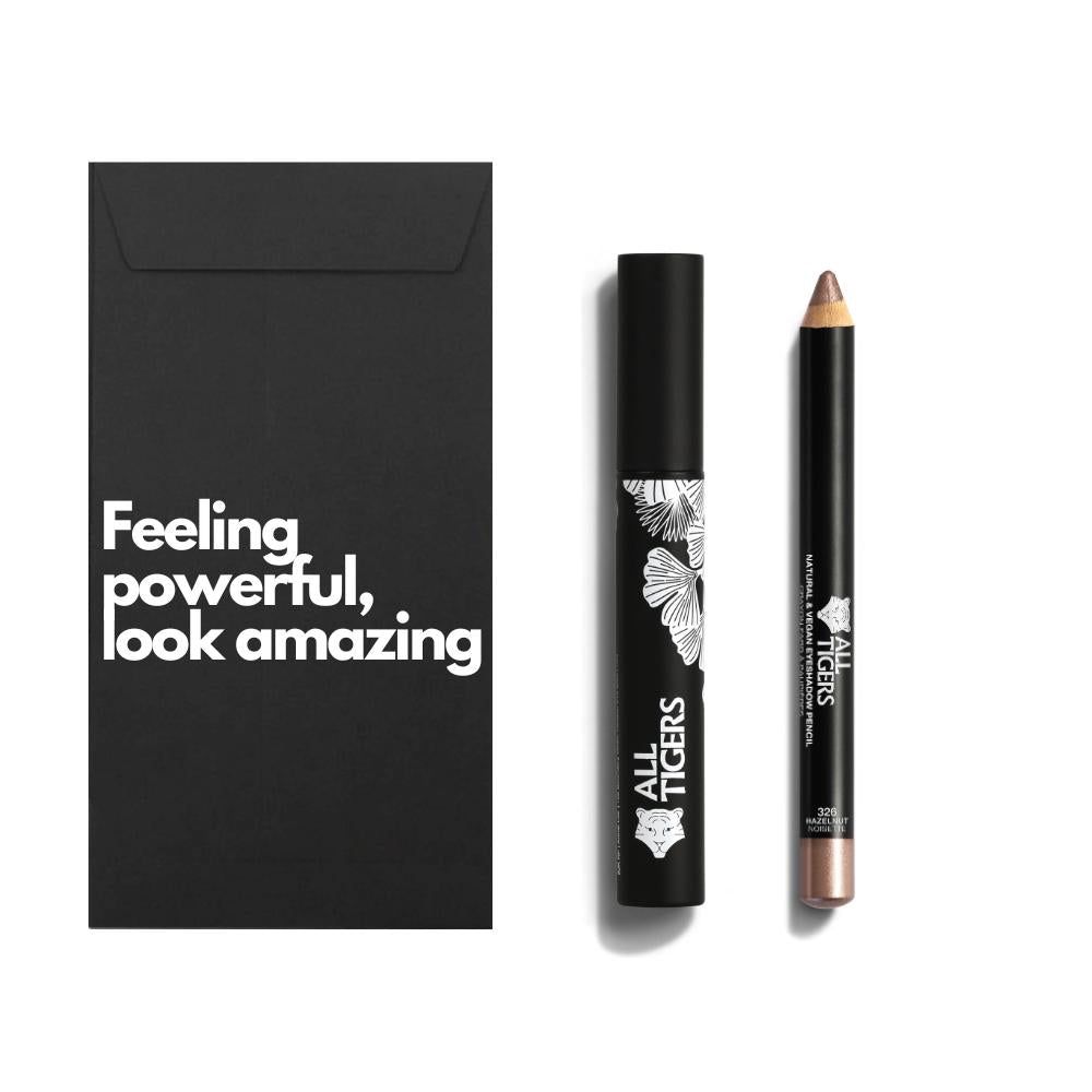 Schwarze Verpackung mit Text. Mascara und Stift daneben. Mascara mit weißem Muster und Logo. Stift mit goldener Spitze.