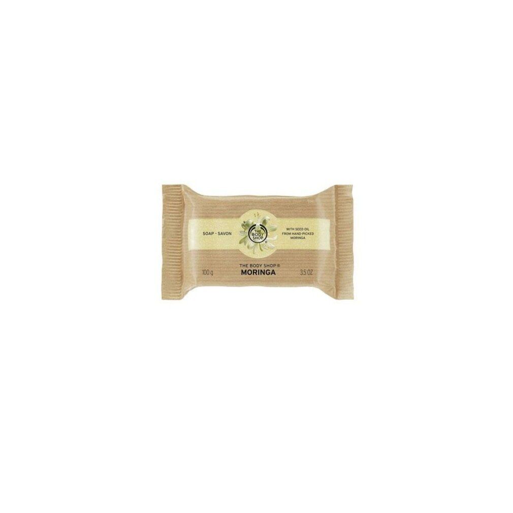 Seife in Papierverpackung. Aufschrift: Moringa, The Body Shop. Braune Verpackung.