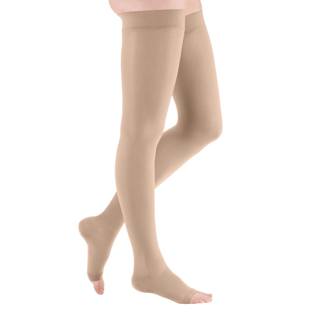 Beige Kompressionsstrümpfe bis zum Oberschenkel. Offene Fußspitze und Haftband am oberen Rand.