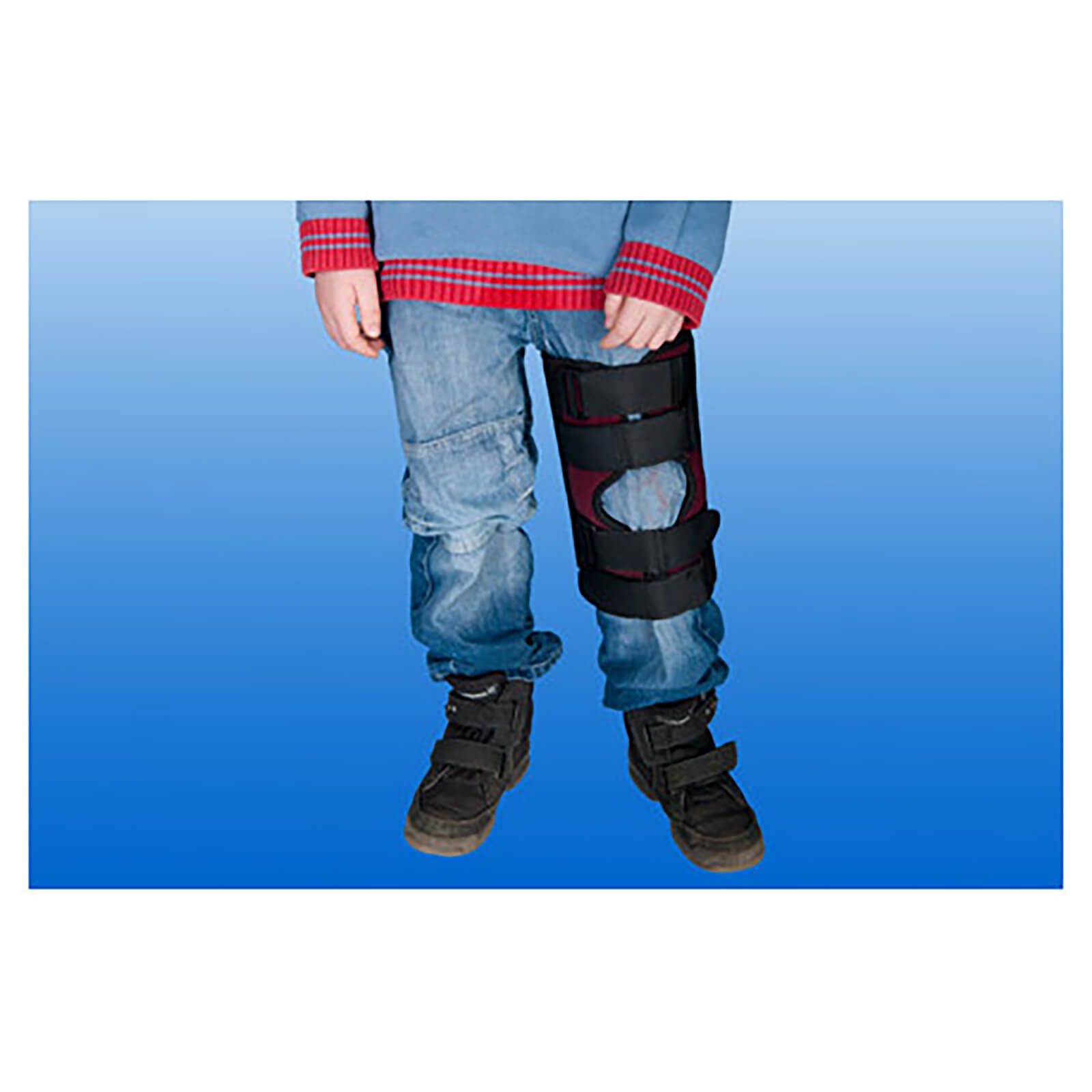 Knieschiene am Bein eines Kindes. Schwarze Gurte, rotes Innenfutter. Knieorthese am Bein befestigt.